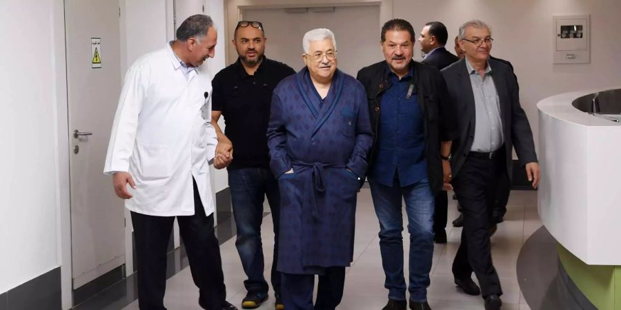 Palästinenserpräsident Mahmud Abbas (3.v.l) geht über einen Flur in einem Krankenhaus. Er ist nach einer Ohr-Operation wegen einer Lungenentzündung erneut im Krankenhaus.