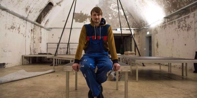 Der fränkische Kabarettist Andy Sauerwein sitzt auf einem Teil der Bühne. Der fränkische Kabarettist Andy Sauerwein sitzt auf einem Teil der Bühne.