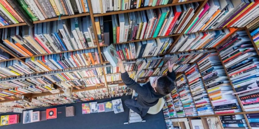 Ein Mitarbeiter der Buchhandlung Walther König in Köln. Foto: Rolf Vennenbernd/dpa