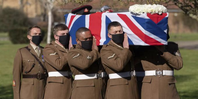 Der Sarg von Sir Tom Moore wird während seiner Beerdigung im Bedford Krematorium in Bedford, England, am Samstag, 27. Februar 2021, von Mitgliedern der Streitkräfte getragen. Captain Tom