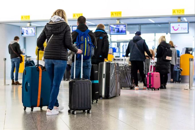 Fluggäste mit dem Reiseziel Mallorca stehen im Flughafen Hannover-Langenhagen am Check-in. Von Hannover aus fliegt der grösste Reisekonzern Tui ab Sonntag nach langer Zwangspause wieder die ersten Urlauber nach Mallorca. Coronavirus - Tourismus