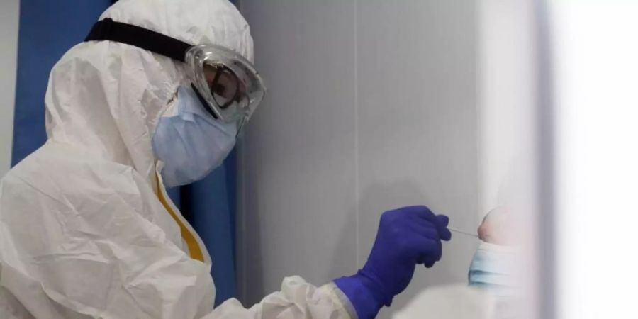 Eine Mitarbeiterin des Gesundheitswesens nimmt von einer Frau einen Abstrich für einen Corona-Test. Foto: Álex Zea/EUROPA PRESS/dpa