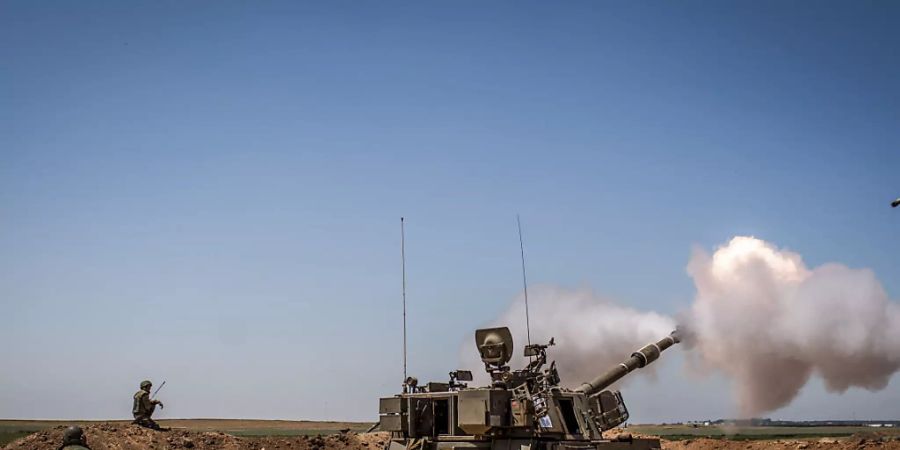 Eine israelische Artillerie feuert von einer Position an der Grenze zwischen Israel und Gaza in der Nähe von Sderot in Richtung des Gazastreifens. Foto: Ilia Yefimovich/dpa