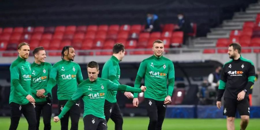 Die Gladbacher Spieler wärmen sich in der Puskas Arena auf - zum Rückspiel soll es nach Manchester gehen. Foto: Marton Monus/dpa