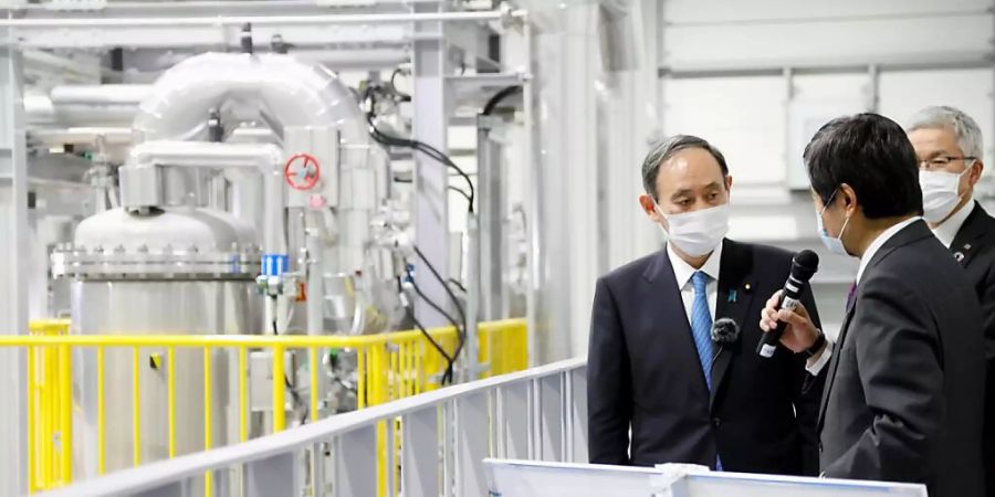 Yoshihide Suga (l), Ministerpräsident von Japan, besucht ein Roboterentwicklungszentrum in der Nähe des havarierten Atomkraftwerks Fukushima Daiichi. Am 11. März 2021 findet der 10. Jahrestag der Tsunami-Katastrophe in Fukushima statt. Foto: ---/Kyodo/dpa