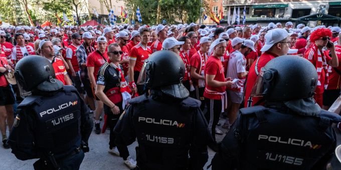 Zahlreiche Fans des 1. FC Union Berlin gehen an Polizisten auf dem Paseo de la Castellana vorbei. Union-Fans