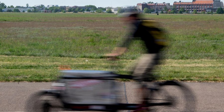 Ein Mann fährt beim sonnigen Wetter auf einem Lastenrad.