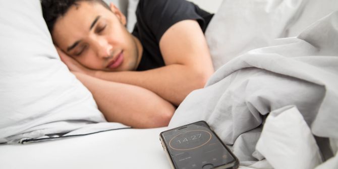 Mann Bett Nickerchen Smartphone Wecker