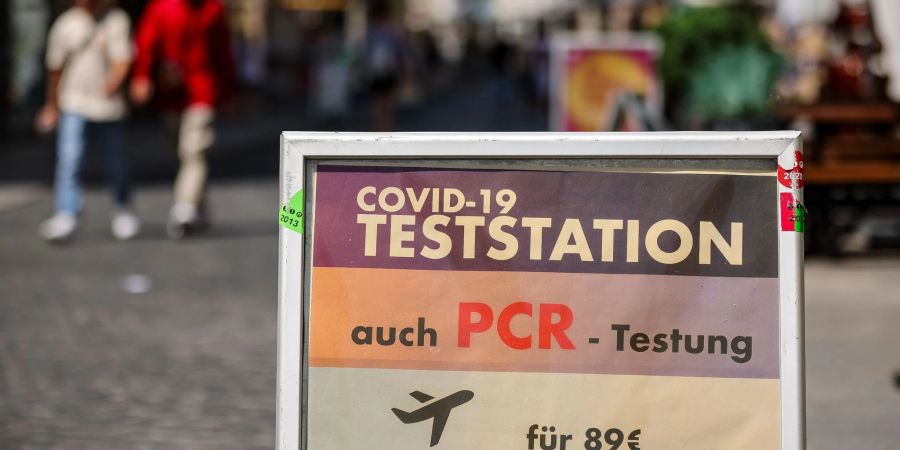 Ein Schild weist in der Innenstadt von Halle auf eine PCR-Teststation hin.