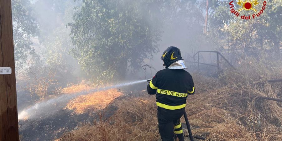 Ein Feuerwehrmann löscht einen Waldbrand auf Sizilien.