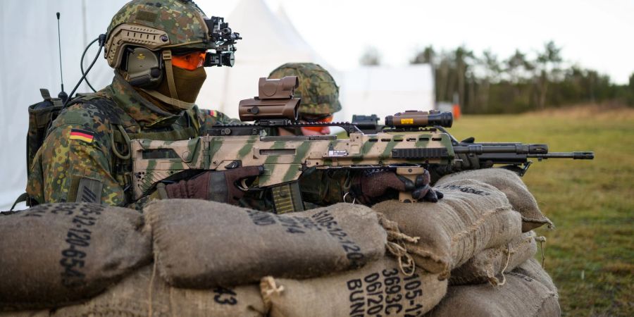 Soldaten der Bundeswehr haben mit dem Sturmgewehr vom Typ G36 A2 während einer Vorführung hinter Sandsäcken Stellung bezogen.