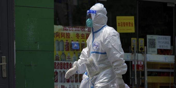 Ein Arbeiter in einem Schutzanzug geht an einem geschlossenen Lebensmittelladen in Peking vorbei. Im Rahmen der Corona-Massnahmen sind die Bewohner unter Hausarrest gestellt worden. coronavirus china