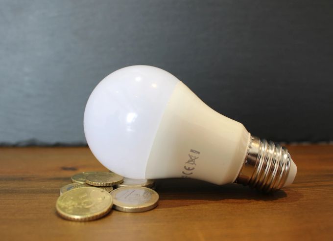 Strompreise werden durch das Gesetz geregelt. Glühbirne Münzen Energie Strom Preis