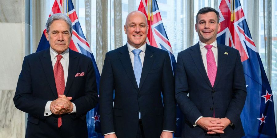 Winston Peters (l-r), designierter stellvertretender Premierminister von Neuseeland, Christopher Luxon, designierter Premierminister von Neuseeland, und der amtierende Regierungschef David Seymour stellen sich bei der Bekanntgabe der neuen Regierung für ein Gruppenfoto auf.