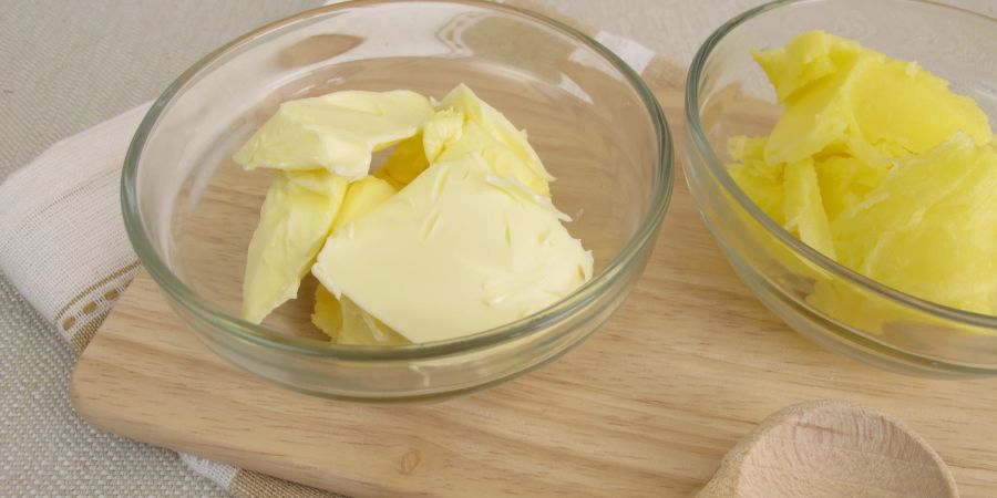 Normale Butter in einer Schüssel neben geklärter Butter. Das Aussehen ist nicht der einzige Unterschied.