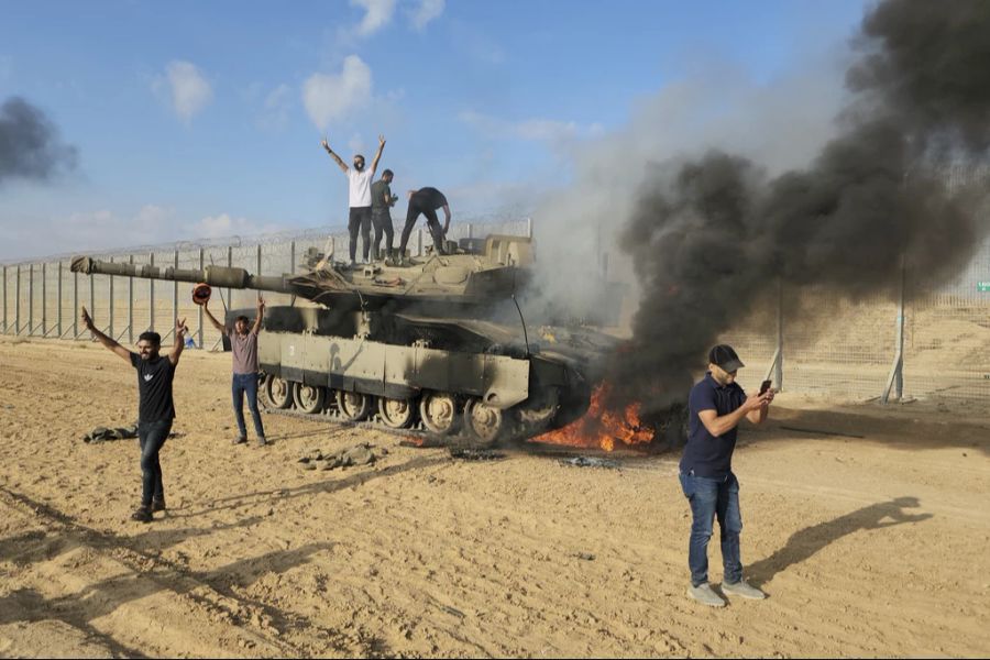 Militante Palästinenser feiern die Zerstörung eines israelischen Panzers.