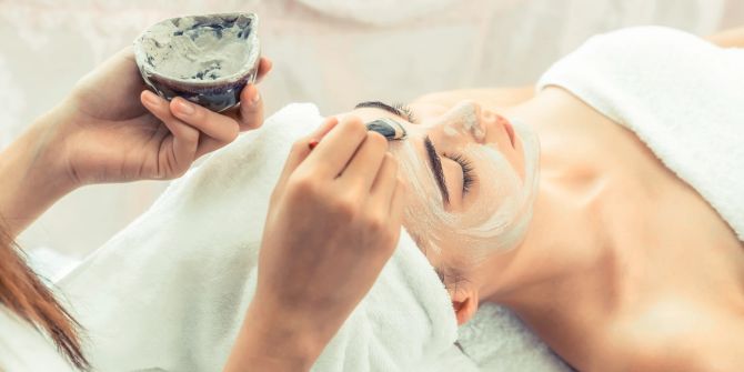 Schöne Frau mit einer kosmetischen Peelingbehandlung für das Gesicht von einem professionellen Dermatologen im Wellness-Spa.