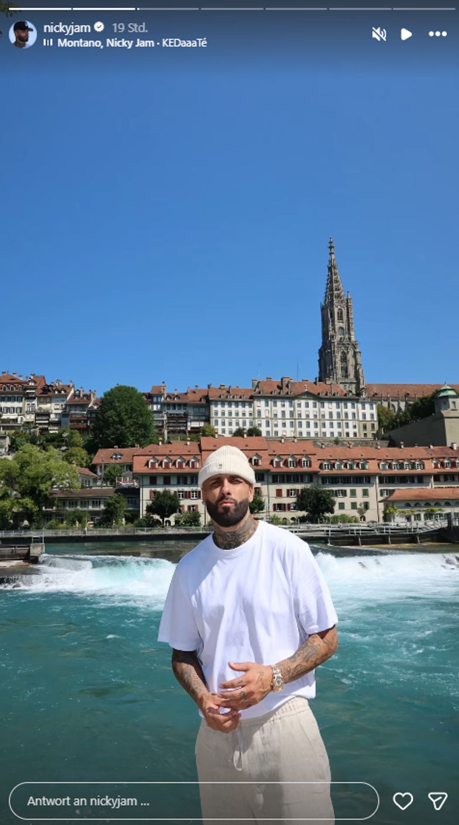 Nicky Jam posiert für ein Foto, im Hintergrund ist das Berner Münster zu sehen.
