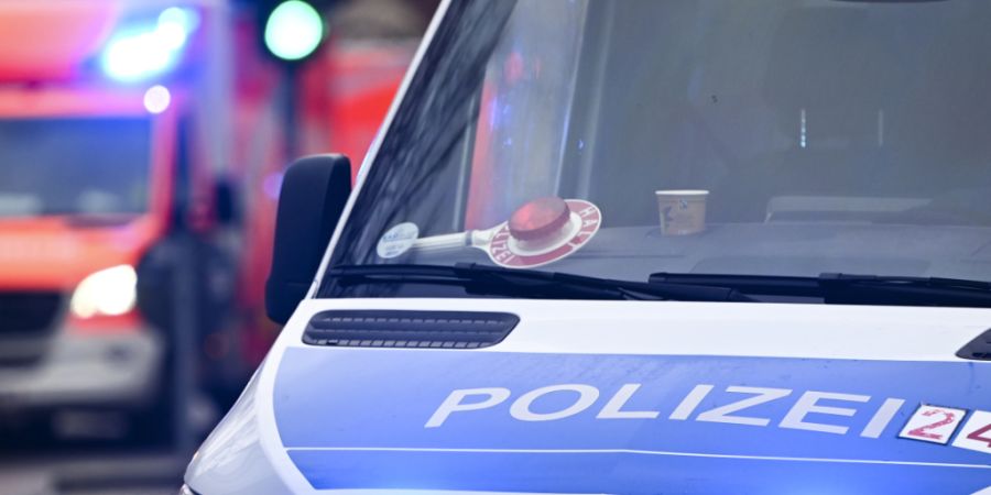 ARCHIV - Ein Polizeiauto und ein Rettungswagen mit Blaulicht. Foto: Jens Kalaene/dpa/Archivbild