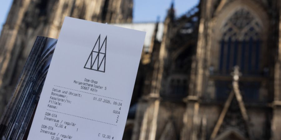 Eine Touristin zeigt ihr Ticket vor dem Kölner Dom. Der Eintritt in den Kölner Dom kostet ab dem 1. Juli zwölf Euro für Besucher. Betende sollen in einen bestimmten Bereich weiterhi...