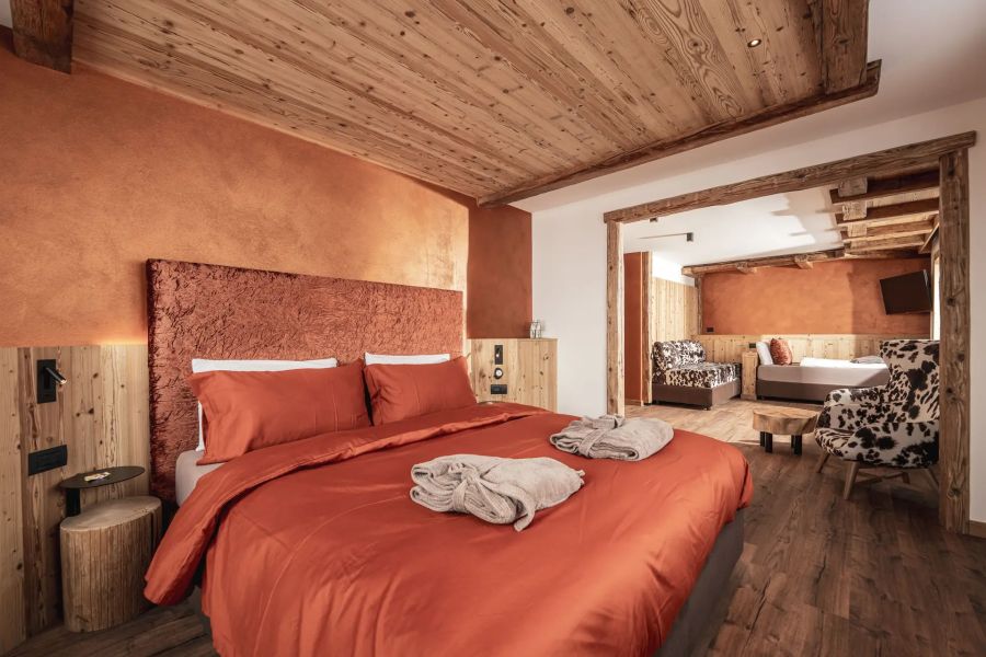 Samtene Doppelbetten, Bademäntel und ein offener Wohnbereich: Von Hüttenromantik ist in den Suiten wenig zu spüren.