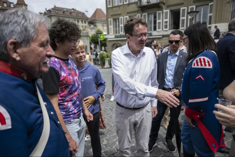Nicht jeder, der eine dunkle Sonnenbrille trägt, gehört zum Sicherheitspersonal. Der Mann hinter Bundesrat Albert Rösti während der Bundesratsreise 2023 in Freiburg aber schon.
