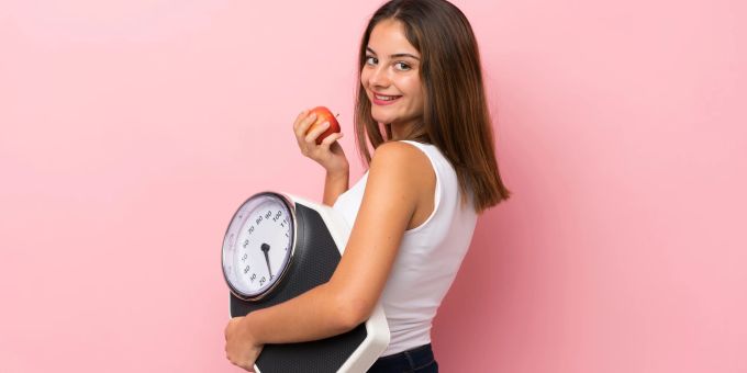 Wer langfristig abnehmen will, sollte nicht auf kurzfristige Diäten setzen. Frau mit Waage