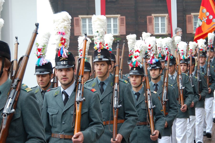 Soldaten marschieren in Uniform und mit Gewehren