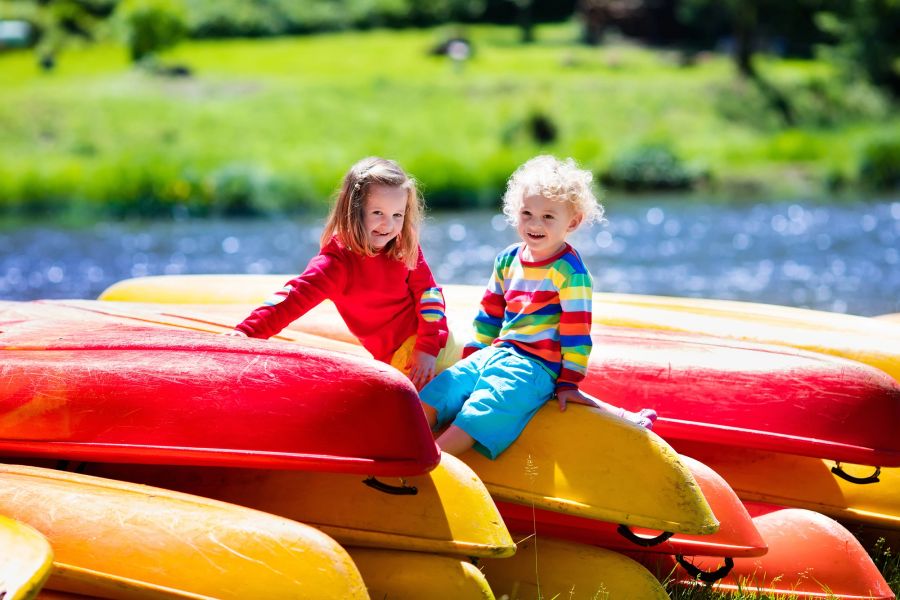 Kinder im Sommer am Wasser, Boote