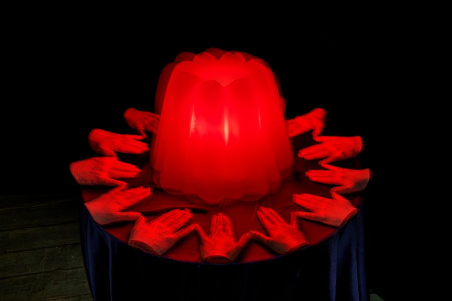 Skurril! Abgetrennte Hände vor einem rot-leuchtenden Wackelpudding.