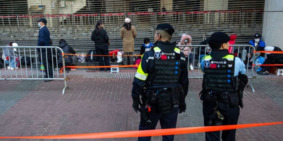 Menschen warten vor dem West Kowloon Magistrates' Courts auf die Urteilsverkündung im Prozess gegen den Hongkonger Aktivisten und Verleger Jimmy Lai im Zusammenhang mit der nationalen ...