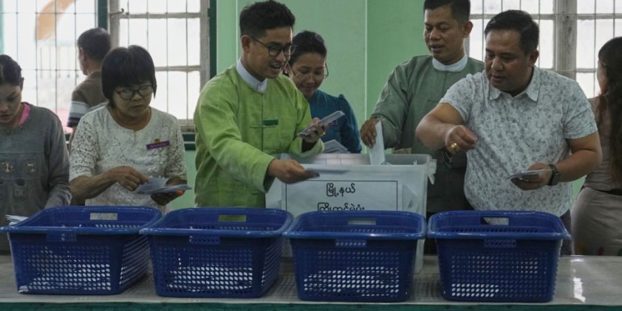 Beamte der Wahlkommission der Union bereiten sich auf die Auszählung der vorzeitig abgegebenen Wahlzettel in einem Wahllokal vor. Foto: Thein Zaw/AP/dpa