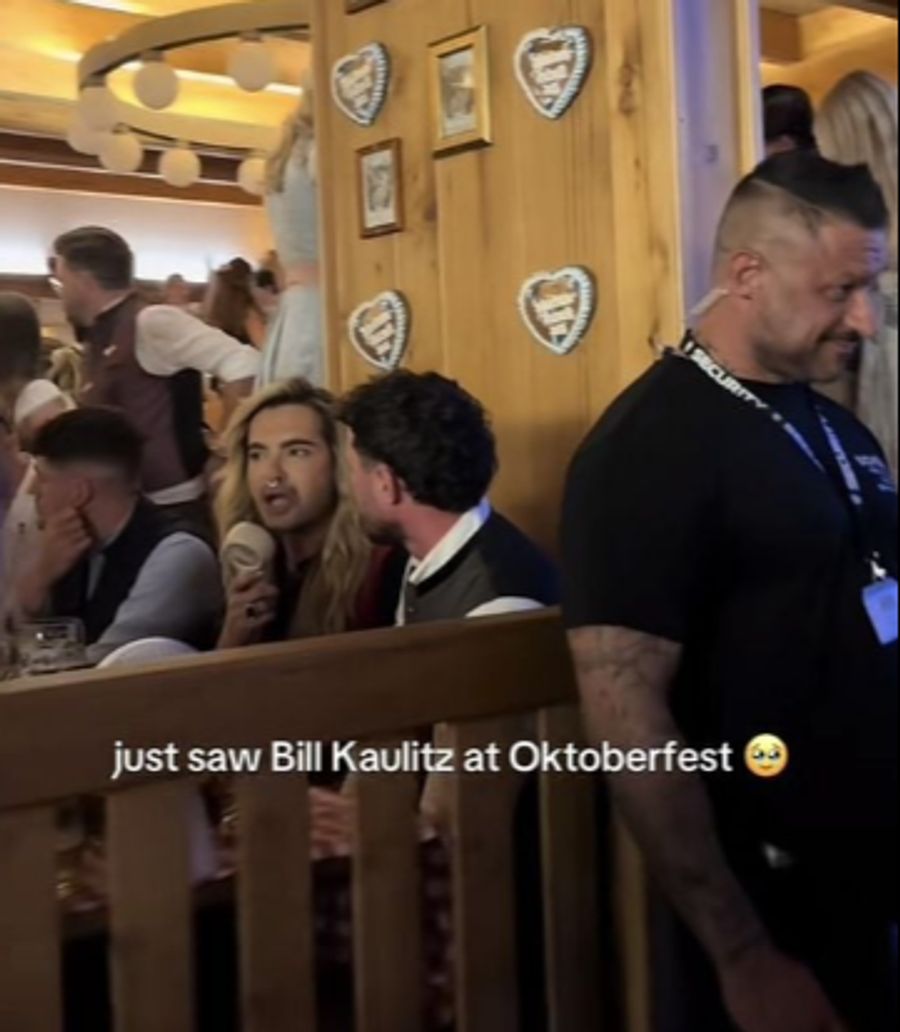 Bill Kaulitz auf dem Oktoberfest. Neben ihm sitzt Jannik.