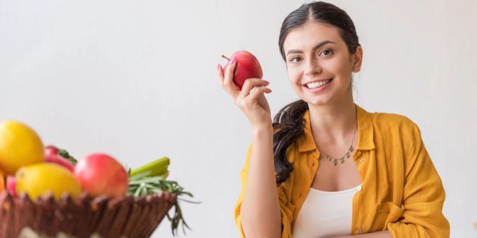 Wer vegan isst, sollte sich mit den Grundlagen der Ernährung auskennen. Frau isst vegan