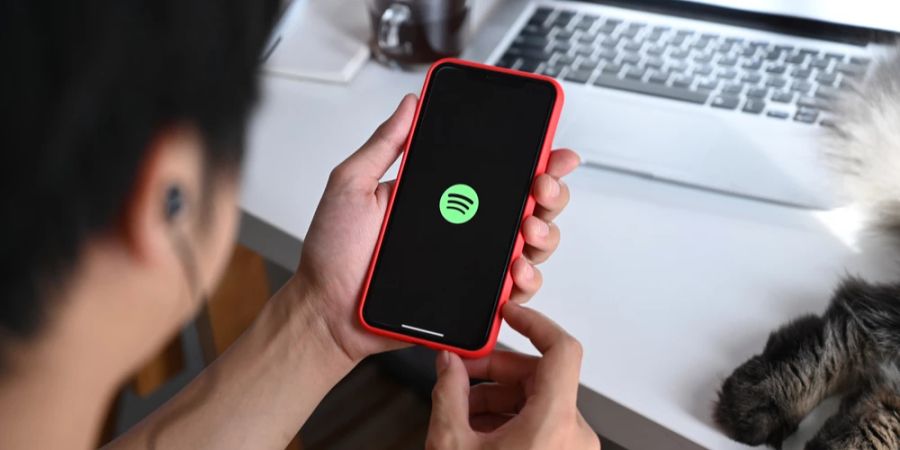 Mann Smartphone Spotify-App PC Schreibtisch