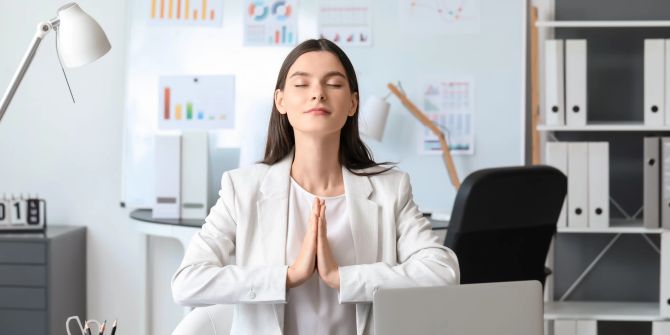 Meditierende Frau im Büro