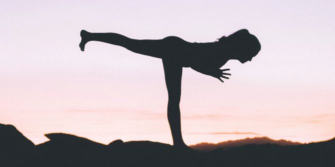 Silhouette einer Frau beim Yoga, vor lila Himmel.