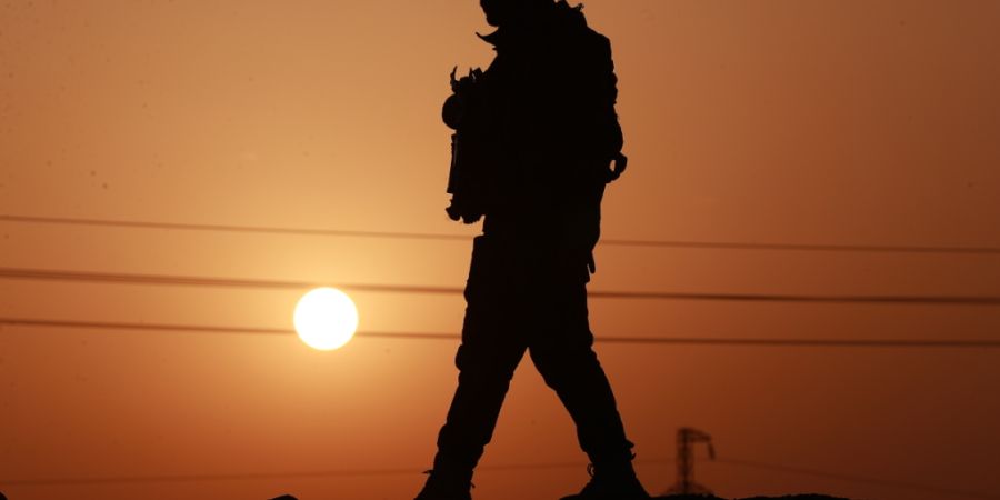 ARCHIV - Ein Mitglied der Popular Mobilization Forces an einer Betonmauer an der irakisch-syrischen Grenze in Al-Qaim, im Westen des Irak. Auch im Irak kommt es in mehreren Landesteilen...