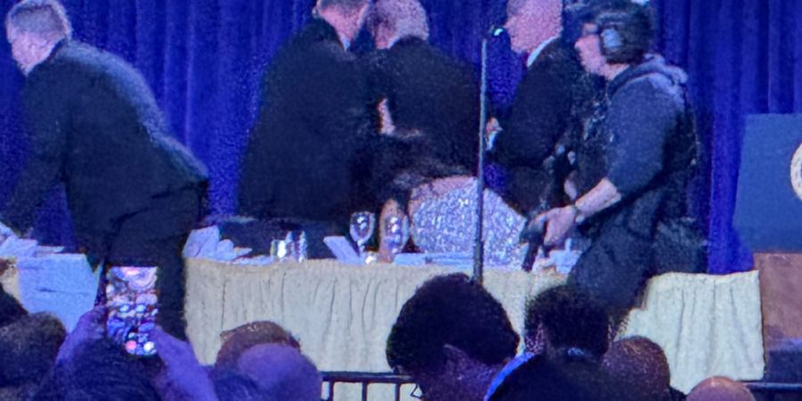US-Geheimdienstmitarbeiter umringen US-Präsident Donald Trump nach den Schüssen während des White House Correspondents' Dinner. Foto: Mark Schiefelbein/AP/dpa