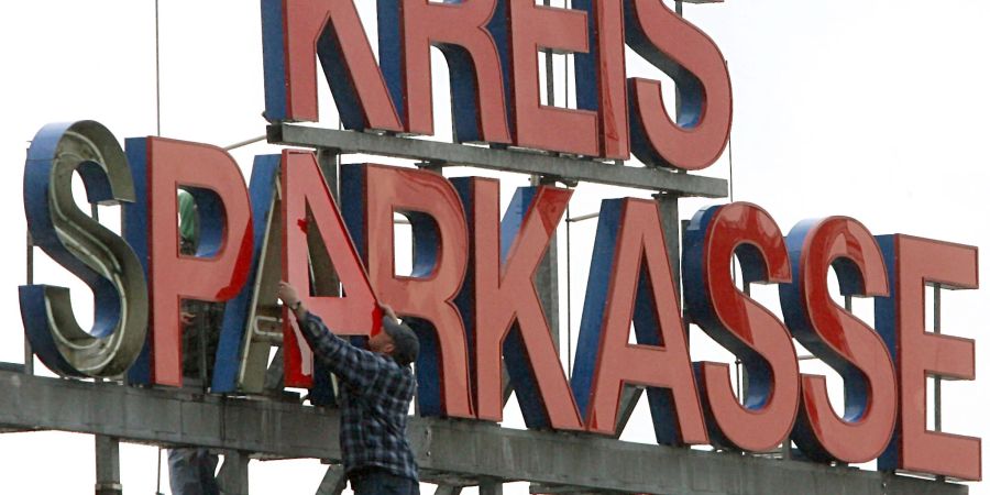 Arbeiter montieren den Schriftzug «Kreissparkasse» auf das Dach der Firmenzentrale. Fast eine Million Euro sind bei der Bank aus einem Tresorraum verschwunden.