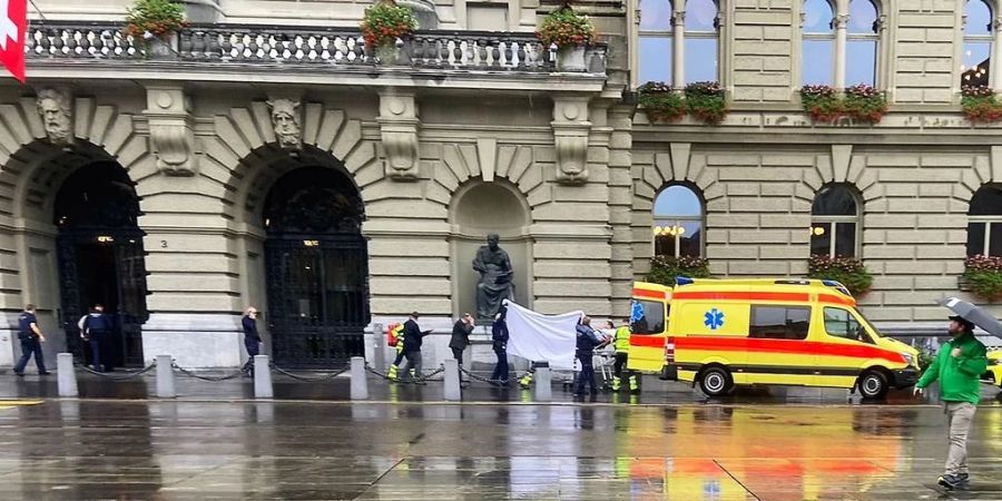 SVP-Nationalrat Lukas Reimann wird nach seinem Zusammenbruch in ein Ambulanz-Fahrzeug gebracht.