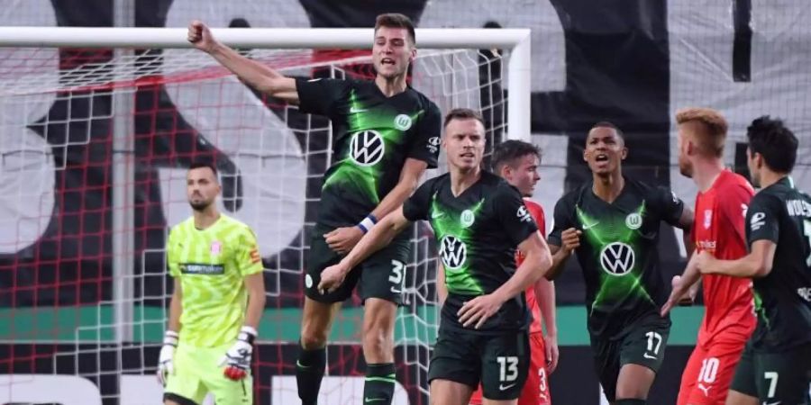 Halle-Keeper Kai Eisele (l-r) ist geschlagen, Wolfsburgs Robin Knoche feiert sein Tor zum 4:3. Foto: Hendrik Schmidt