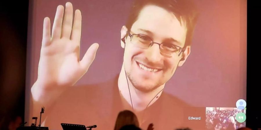 Der NSA-Enthüller Edward Snowden winkt von einer Videoleinwand (2014). Foto: Wolfgang Klumm