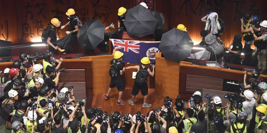 Demonstranten hängen im Parlament die Fahne der ehemaligen britischen Kolonie auf.