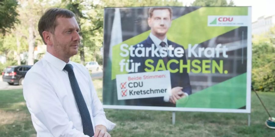 Ministerpräsident Michael Kretschmer vor einem Wahlplakat