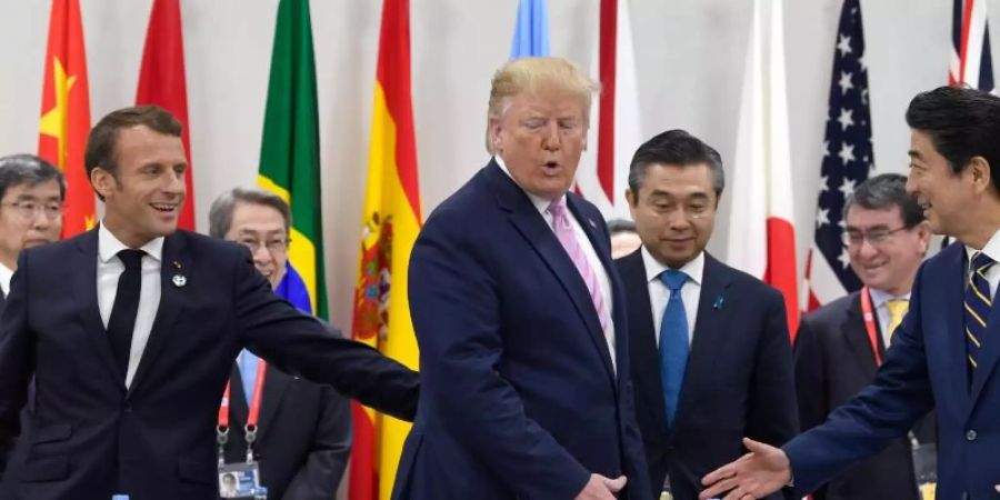 Das grosse Händeschütteln: Frankreichs Präsident Emmanuel Macron (l.), US-Präsident Donald Trump und der japanische Premier Shinzo Abe. Foto: Susan Walsh/AP