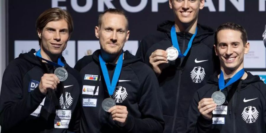 Die deutschen Florettfechter zeigen ihre Medaillen: Peter Joppich (l-r), Benjamin Kleibrink, Luis Klein und Andre Sanitos. Foto: Marius Becker