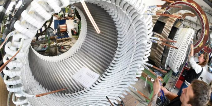 Mitarbeiter arbeiten an Statoren für Elektromotoren Mitarbeiter arbeiten an Statoren für Elektromotoren