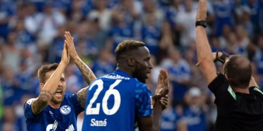 Die Schalker Guido Burgstaller und Salif Sané forderten bei Schiedsrichter Marco Fritz (l-r) ein Handspiel. Foto: Federico Gambarini