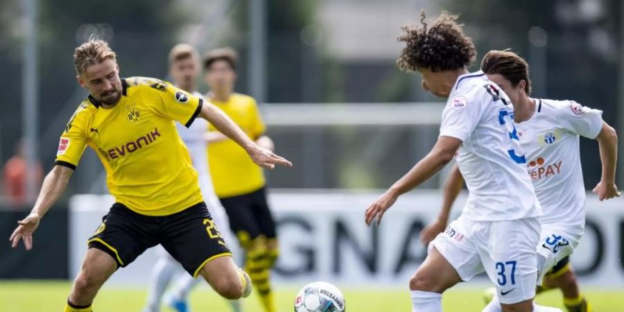 Dortmunds Marcel Schmelzer (l) und Kenit Catari kämpfen um den Ball. Foto: David Inderlied